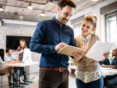 Due colleghi in ufficio che rivedono documenti e lavorano insieme