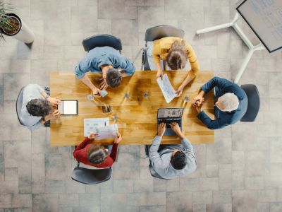 Sala riunioni di una startup team di imprenditori seduti attorno al tavolo conferenze mentre discutono
