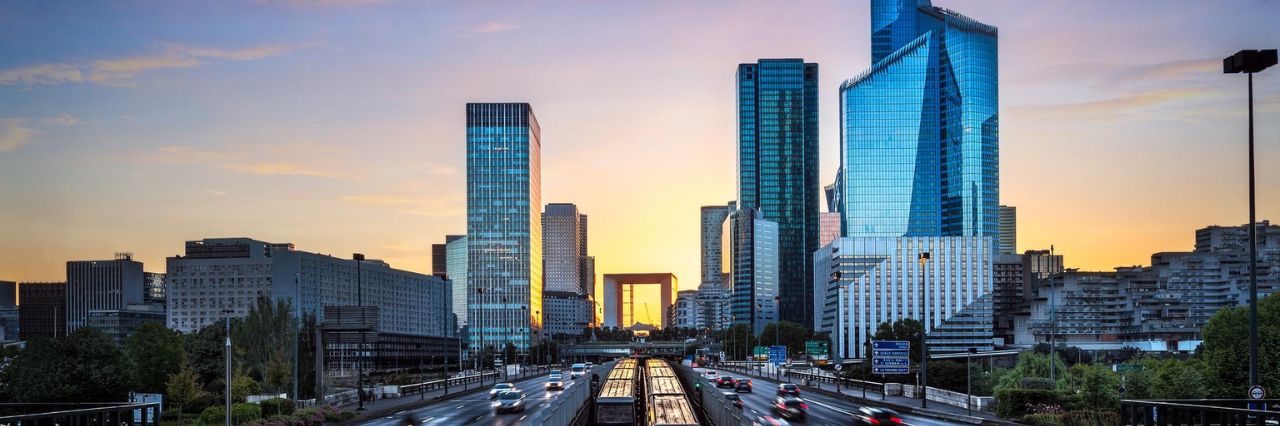 Skyline moderno al tramonto, con grattacieli in vetro che riflettono luce dorata