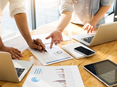 Analisi economica con grafici e laptop su tavolo di lavoro