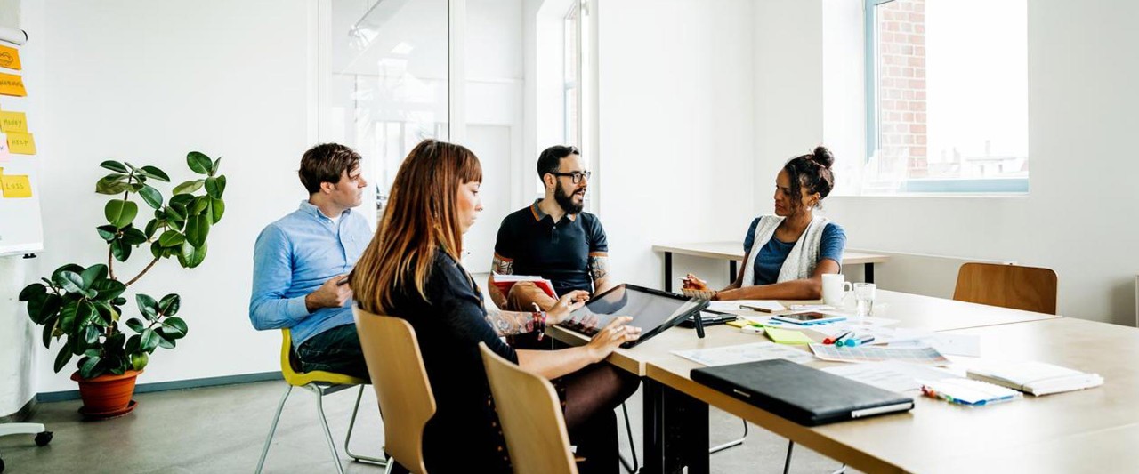 Startup Meeting Room Team of Entrepreneurs sitting at the Conference Table Have Discussions