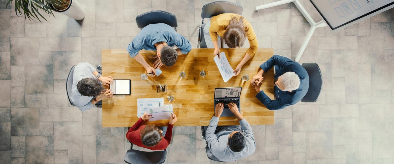Startup Meeting Room Team of Entrepreneurs sitting at the Conference Table Have Discussions
