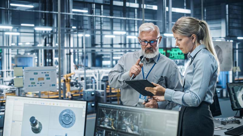 people talks in factory in front of the tablet