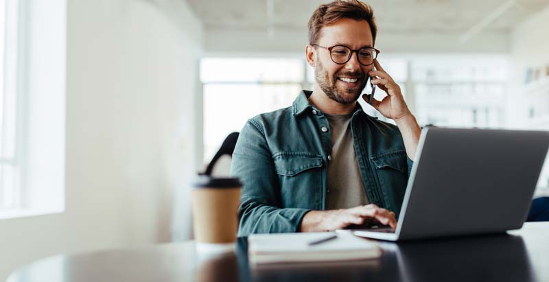 man in front of the desk talking over the phone