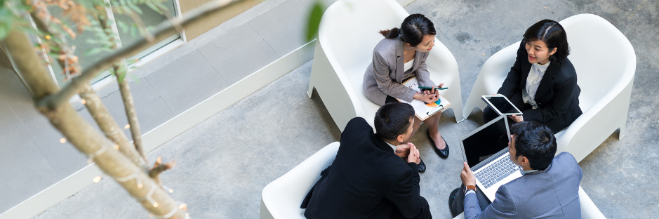 Four-business-people-with-computers-having-a-meeting