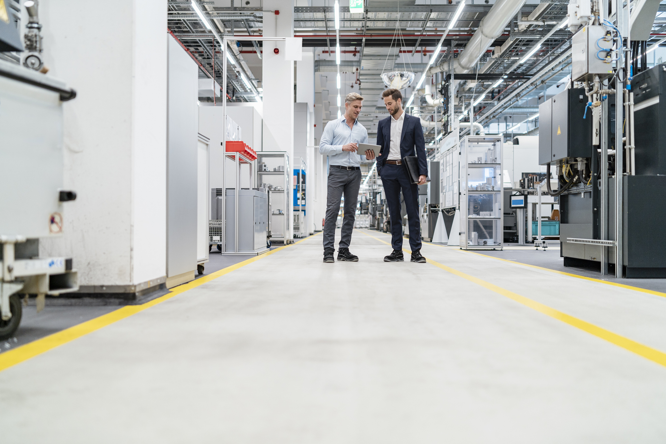 woman standing stoicly with arms crossed with folder in between them