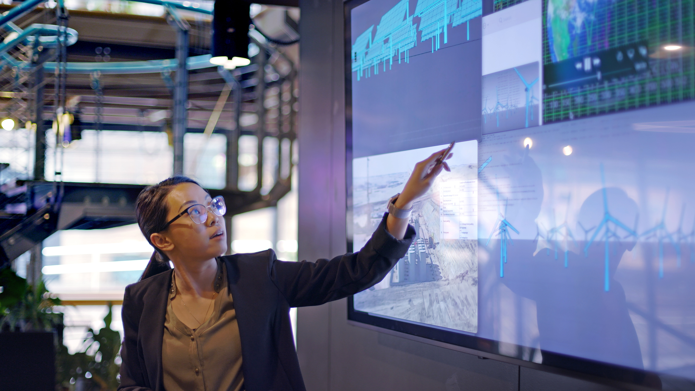 woman pointing toward graph on big tv screen