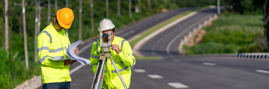 two surveyors using conventional equipment on the side of road