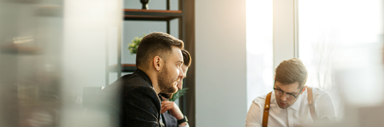 three men in meeting room in workplace