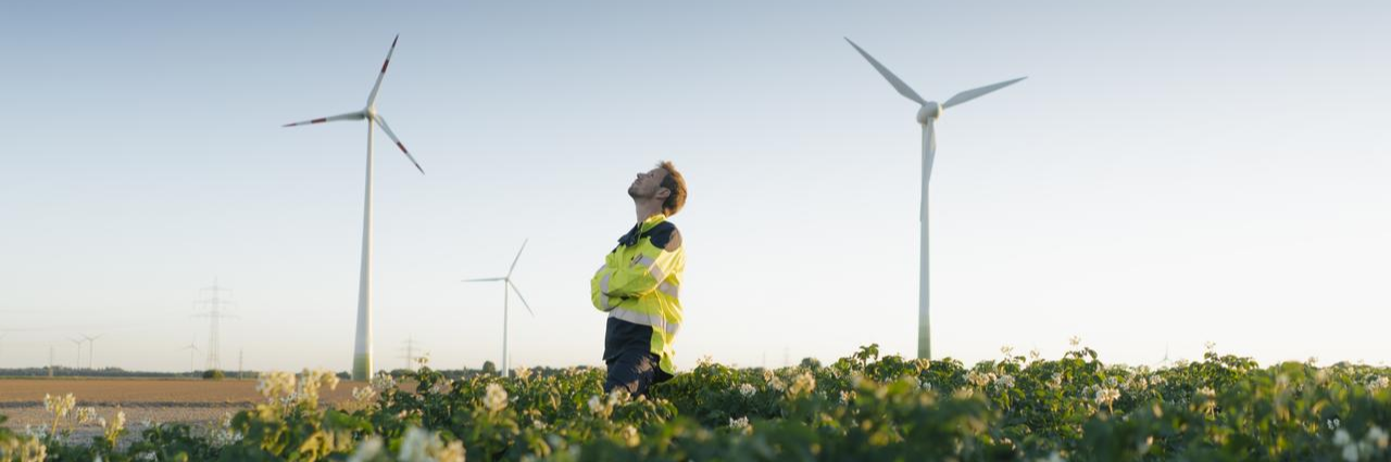 man standing near wind farm