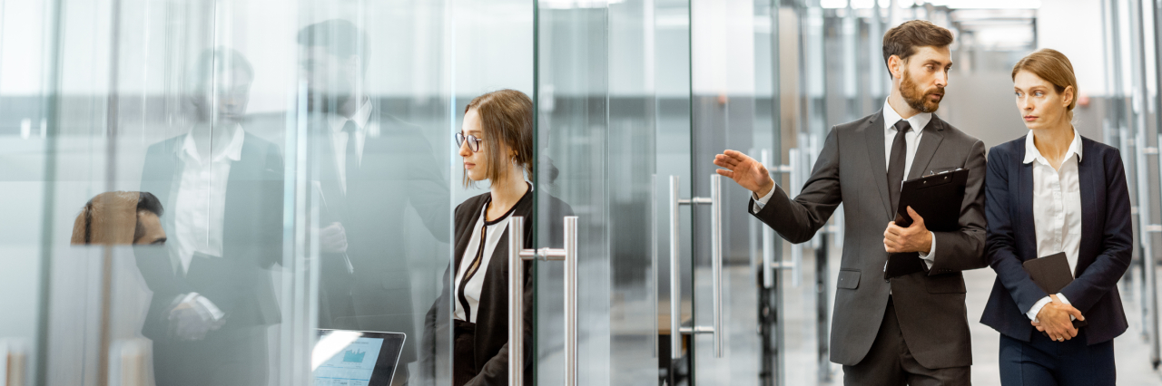 modern office setting with employees walking into conference room