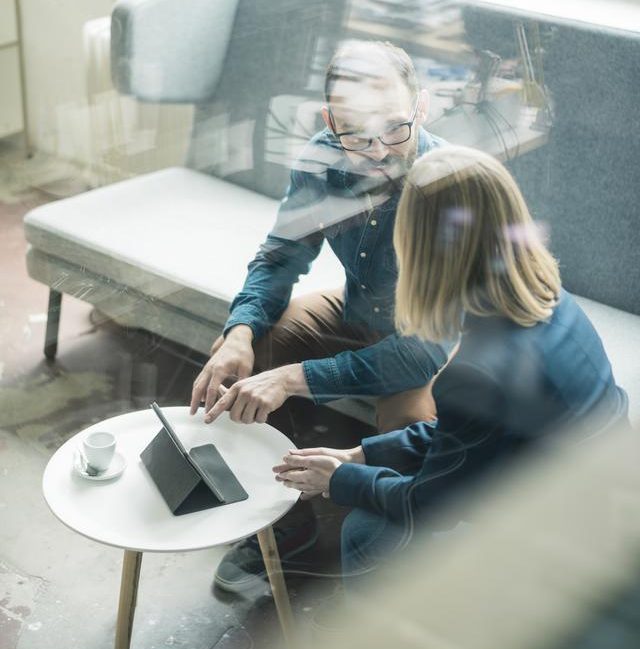Two people discussing business on a couch