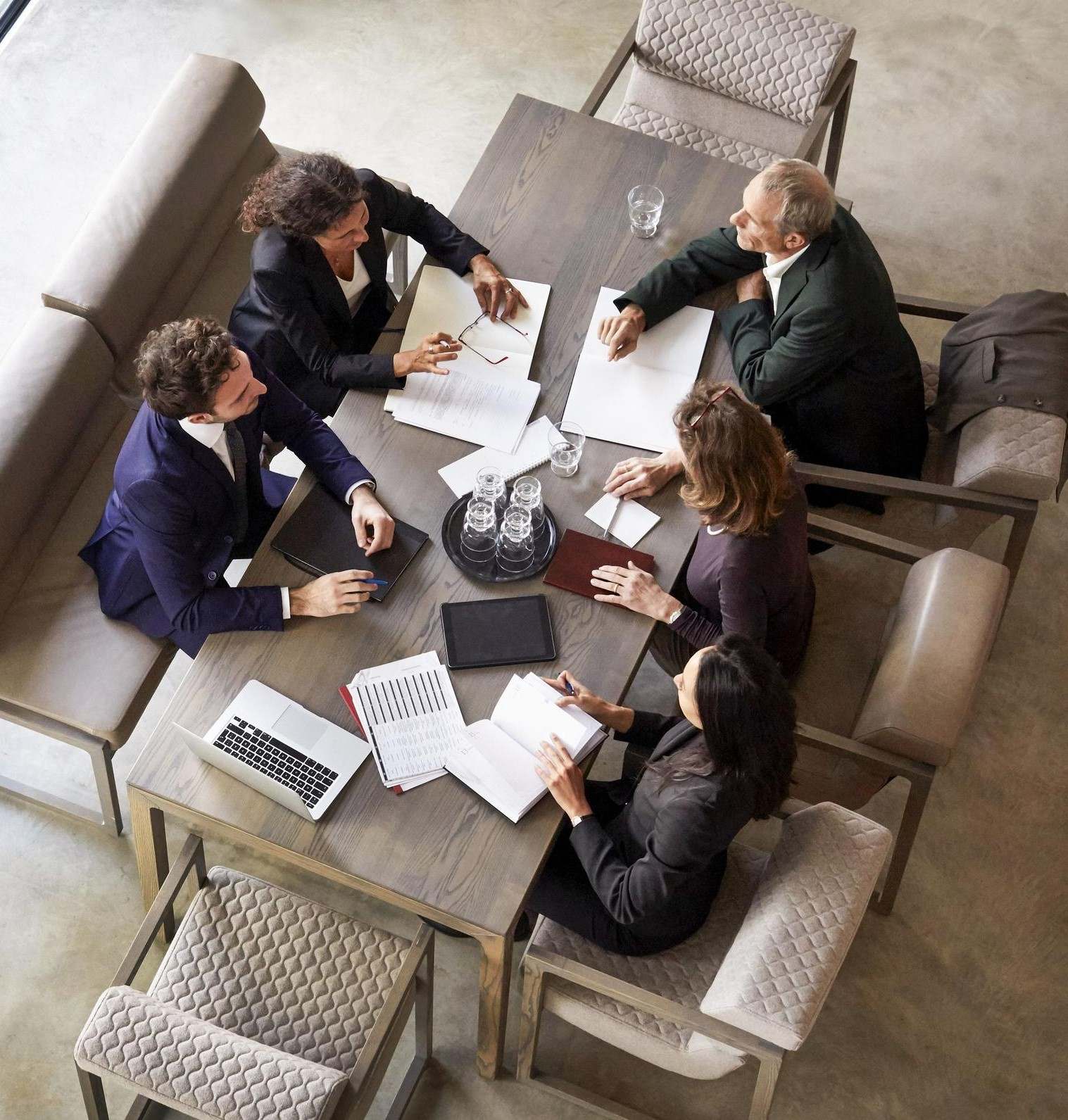 Five colleagues discussing business around a table