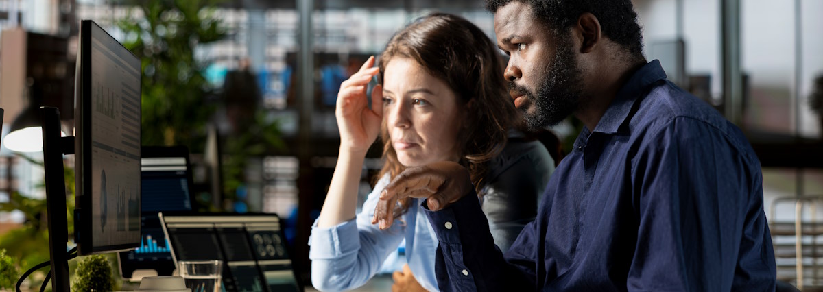 Professional team reviewing performance metrics online using pc software, corporate office life. People engaged in strategic planning to develop the multinational company financial situation