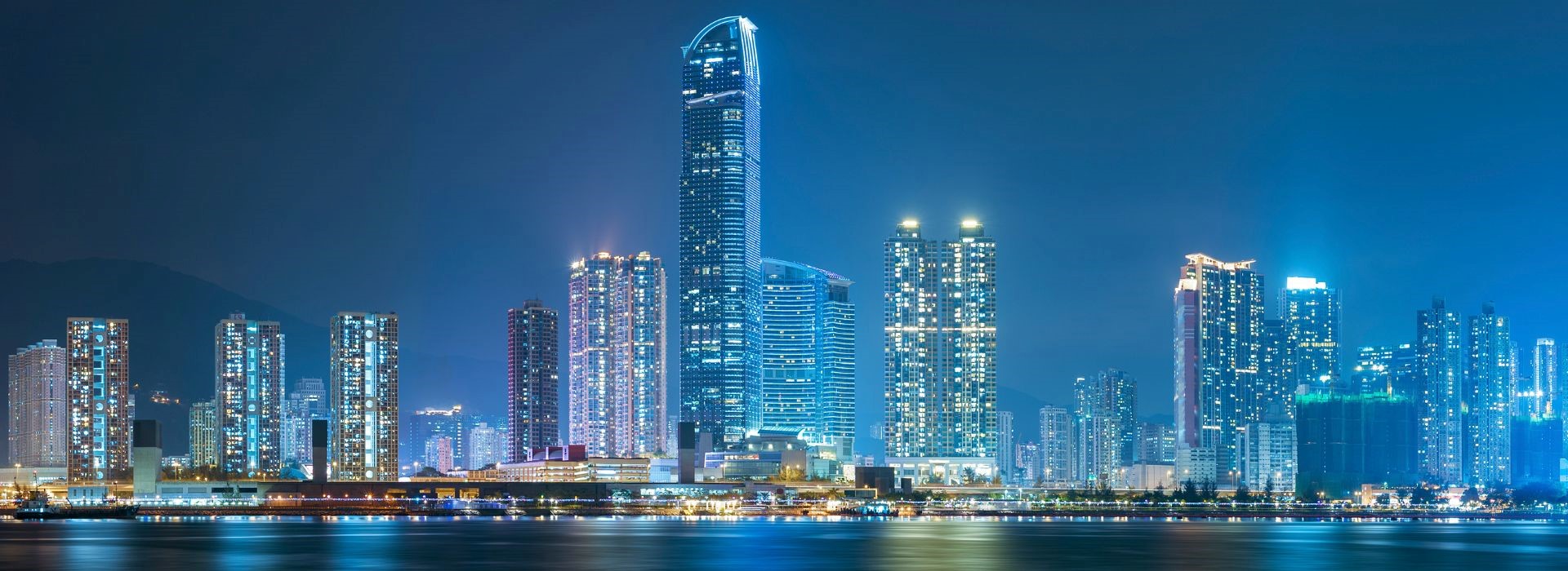 Vista di città moderna di sera, con grattacieli illuminati
