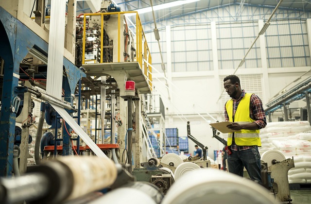 Un tecnico manutentore effettua dei controlli presso uno stabilimento di produzione cartaria