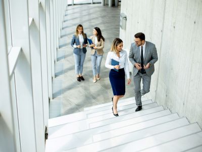 Quattro colleghi di una grande azienda si dirigono alla sala riunioni