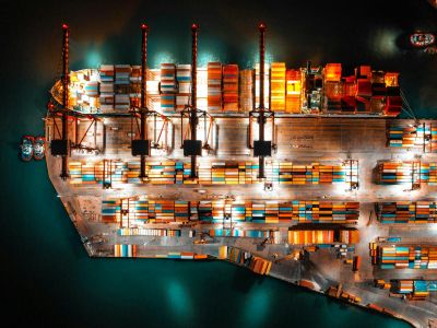 Molo di un porto commerciale con container di merci visto dall'alto, di notte