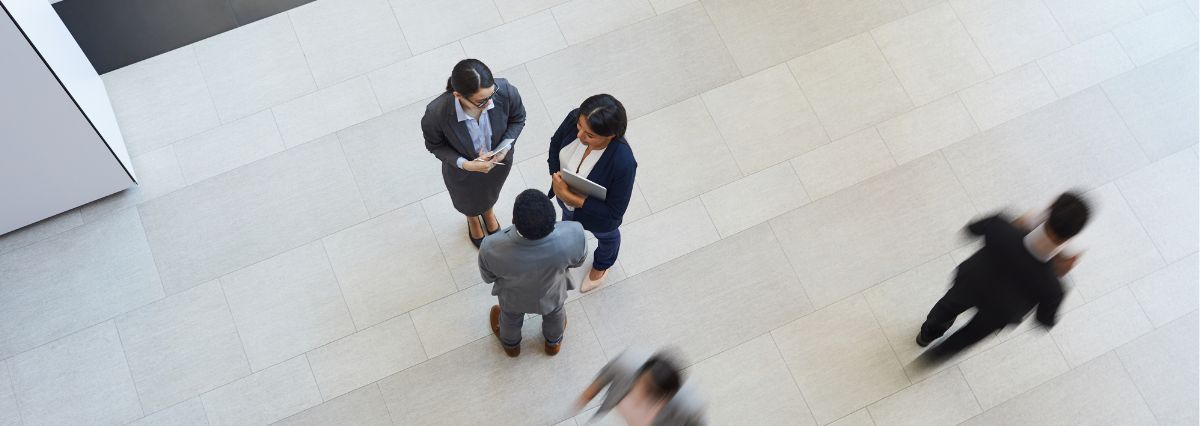 ripresa dall'alto di colleghi in abiti formali nella hall di un ufficio