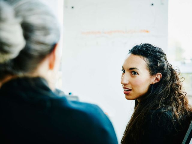 donna che si gira per parlare con un'altra persona che è di spalle
