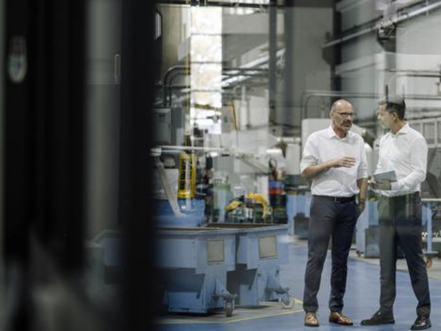 Due ingegneri si confrontano in un impianto industriale