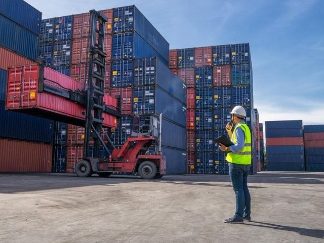 Il capo della logistica dirige le operazioni in un deposito container
