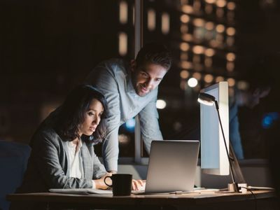 Due colleghi in ufficio terminano di lavorare ad una presentazione al computer