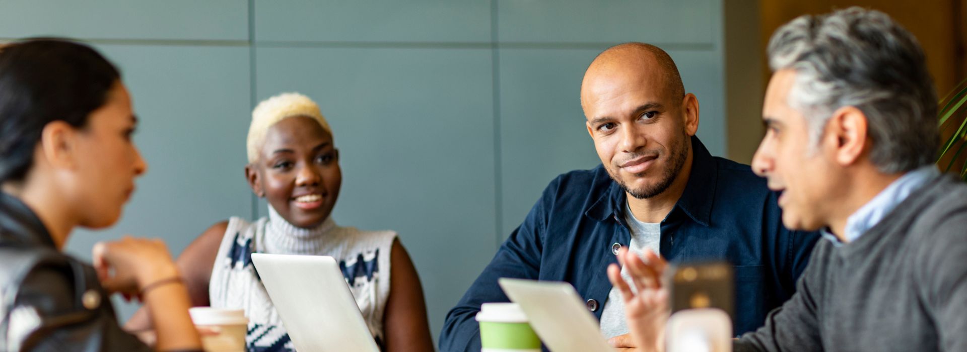 Quattro colleghi si confrontano durante una riunione