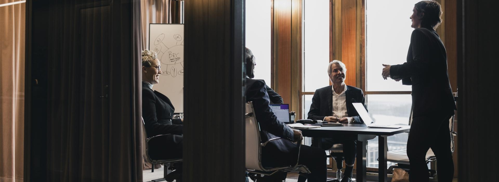 Quattro colleghi ascoltano l'intervento in riunione di una manager