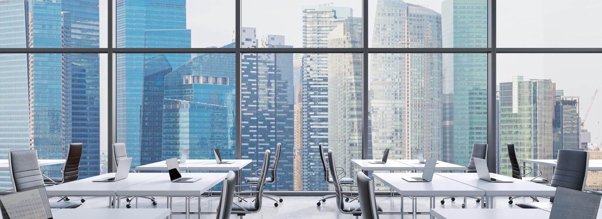 Vista di un ufficio open space con vetrata e panorama cittadino