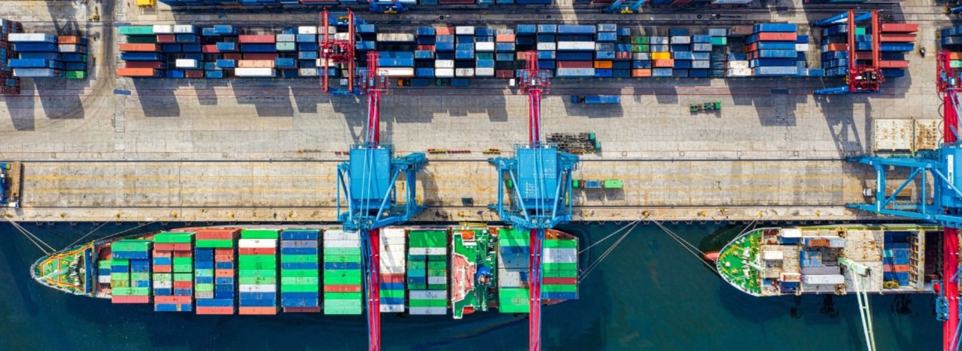 Vista dall'alto del molo di un porto mercantile con container e navi attraccate