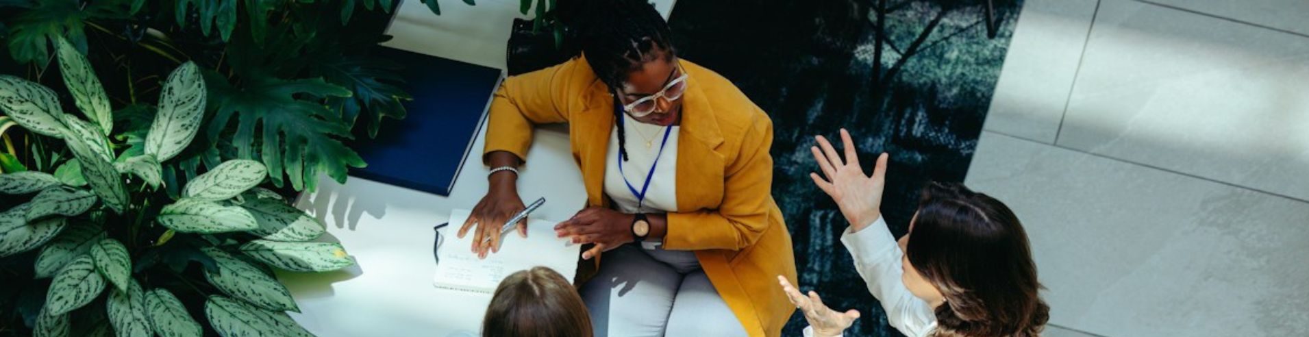 Vista dall'alto di tre manager in ufficio che si confrontano prima di una riunione