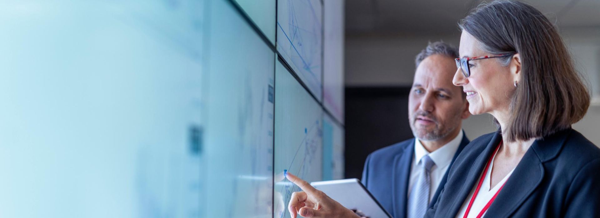 Due business analyst analizzano dei dati su un grafico proiettato