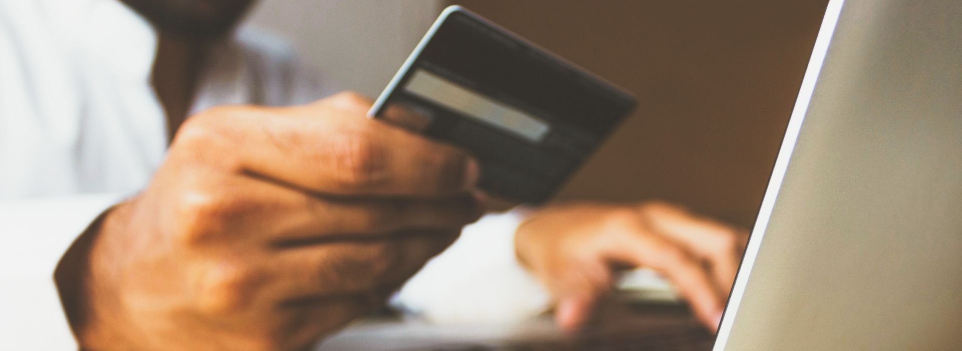 Un uomo inserisce i dati della sua carta di credito per completare un acquisto online