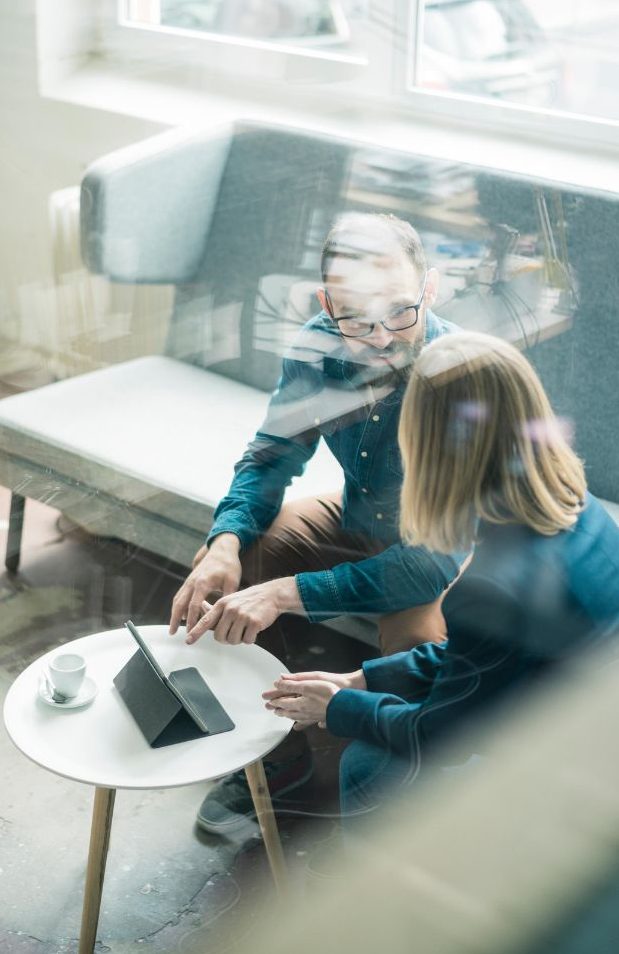 Due colleghi parlano di business seduti su un divano