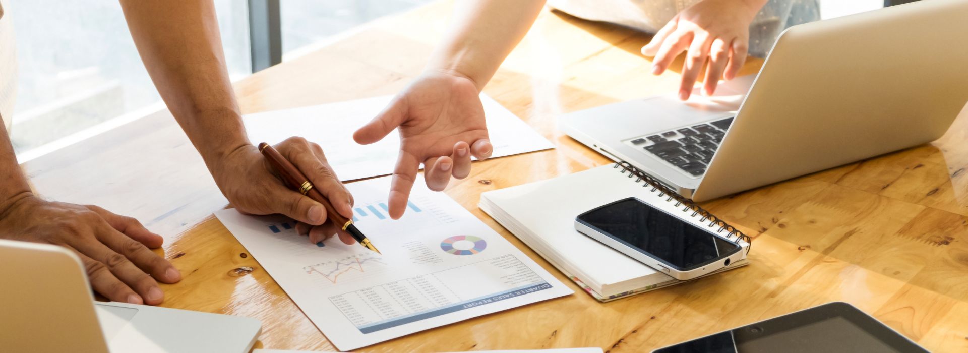 Analisi economica con grafici e laptop su tavolo di lavoro