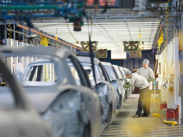 Due operai lavorano in un'industria automobilistica