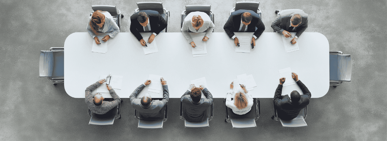 Vista aéria de pessoas a colaborar durante uma reunião de trabalho sobre Mutinacionais de Média Dimensão