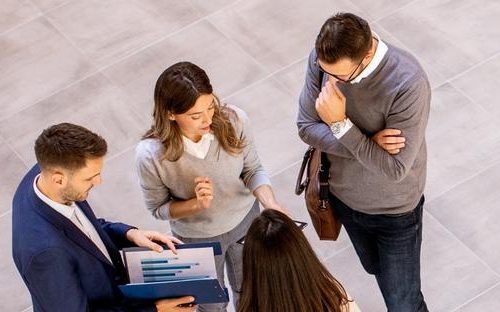 four-business-people-analyzing-graphics-and-having-a-meeting