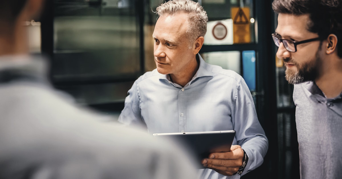 Deux personnes qui discutent autour d'une table, face à un ordinateur