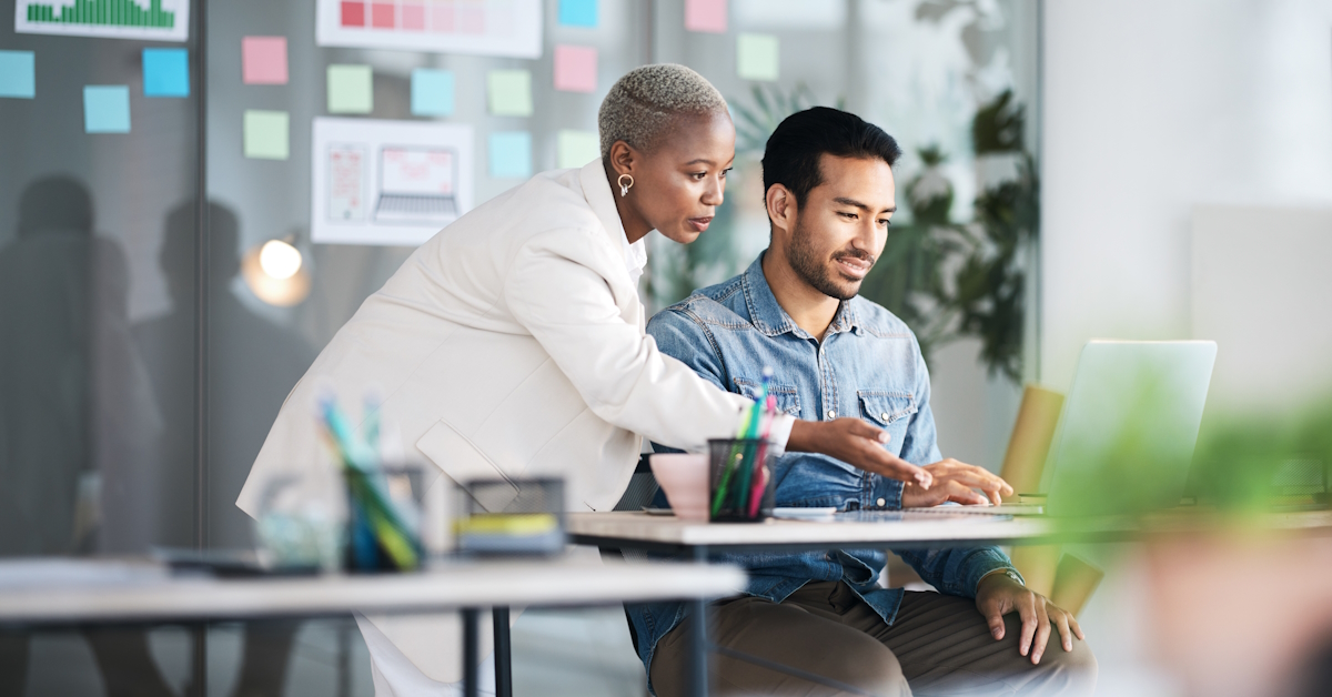 Une femme montre quelque chose sur un ordinateur à un homme