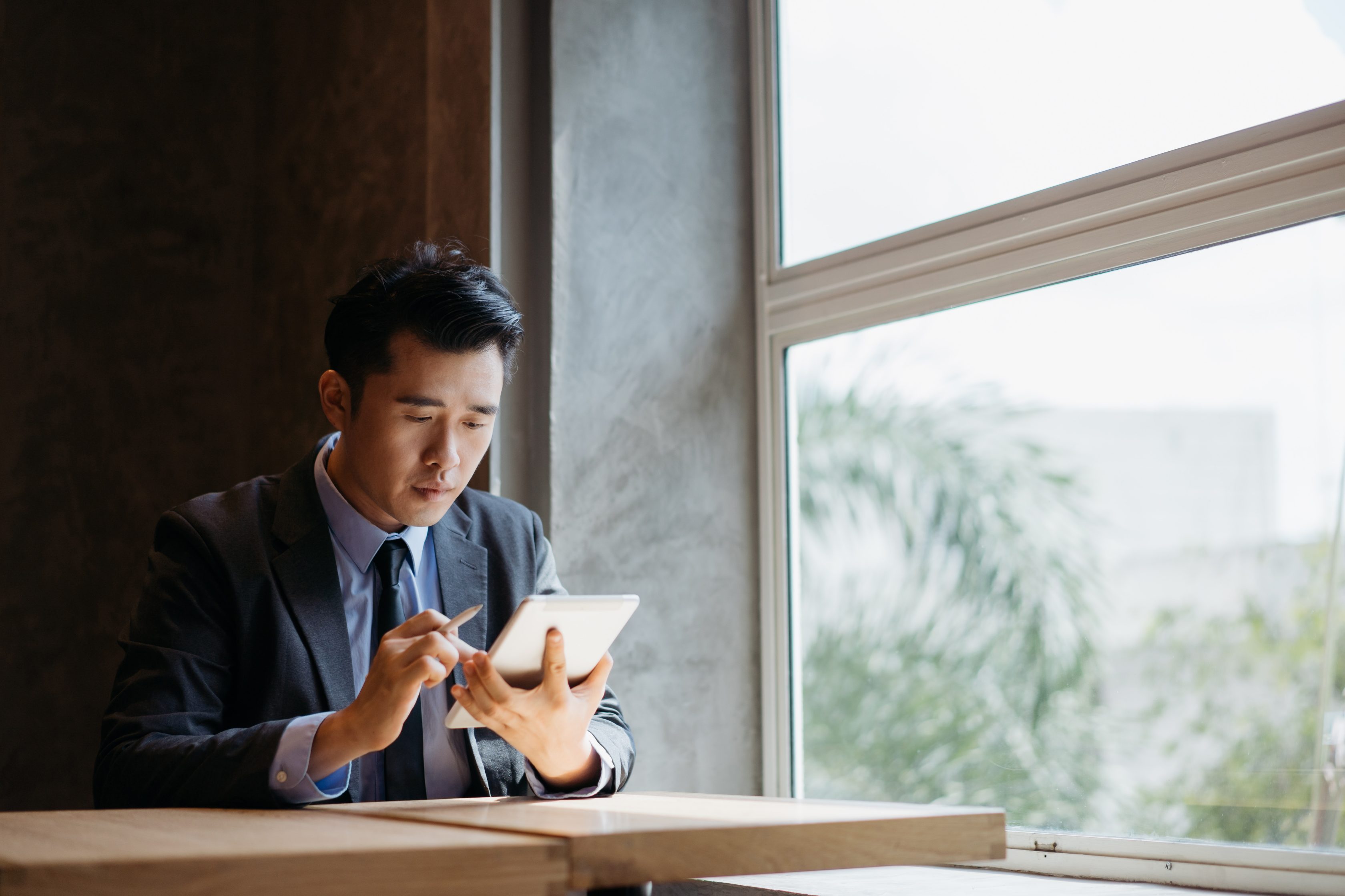 Young asian businessman working on credit solution for SMEs with digital tablet and stylus pen